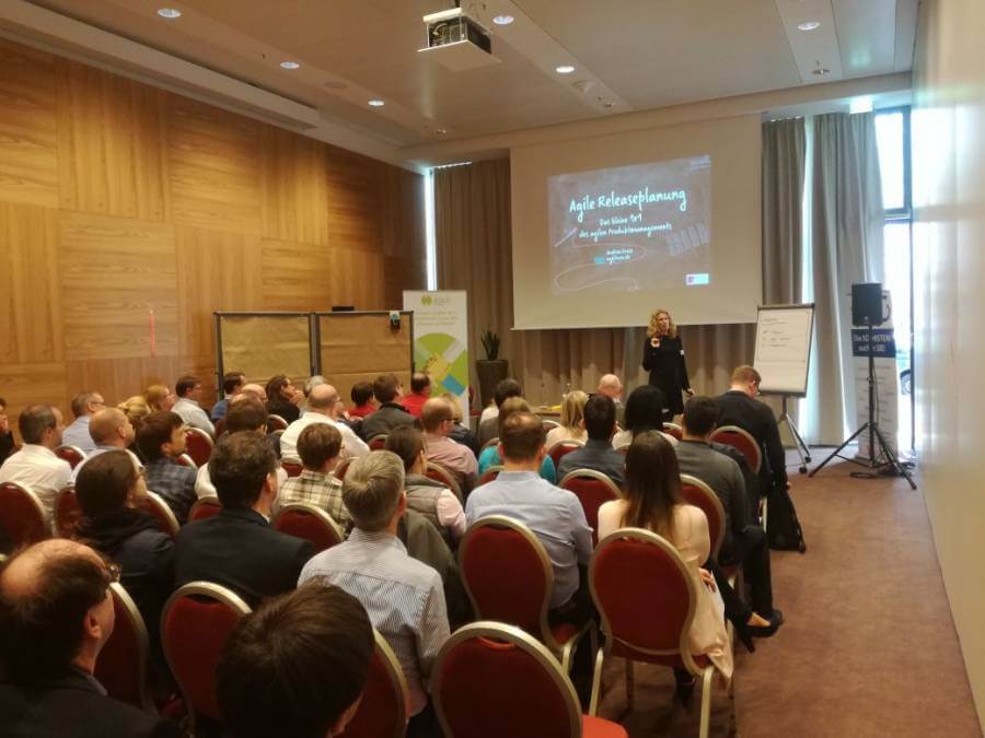 Agile Releaseplanung, agiles Produktmanagement, Andrea Grass, oose, München REConf Agile Releaseplanung - Andrea Grass vor vollen Stuhlreihen und großem Interesse der Teilnehmer